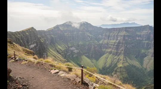 Panorama des pitons et remparts du Parc national de La Réunion avec un sentier balise au premier plan et un large espace de ciel pour du contenu editorial.